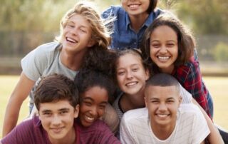 Adolescente pensativo con móvil y agenda de propósitos de año nuevo, reflejando presión emocional