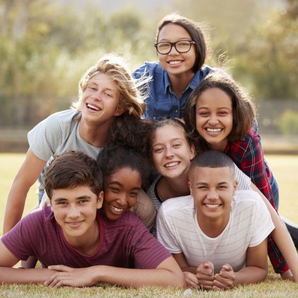 Adolescente pensativo con móvil y agenda de propósitos de año nuevo, reflejando presión emocional