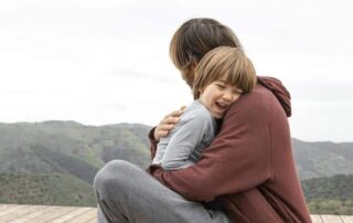 adulto abrazando a un niño mostrando apego seguro