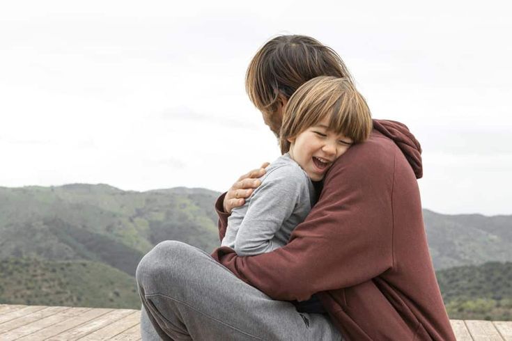 adulto abrazando a un niño mostrando apego seguro